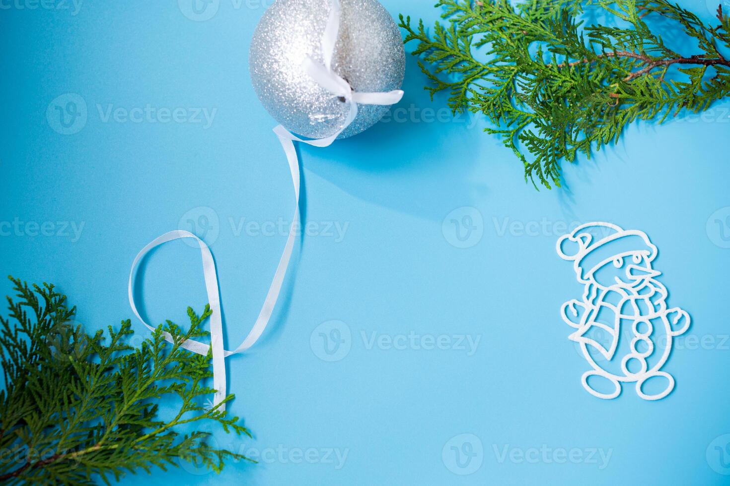 New Year's white ball and snowman on a background with a fir branch photo