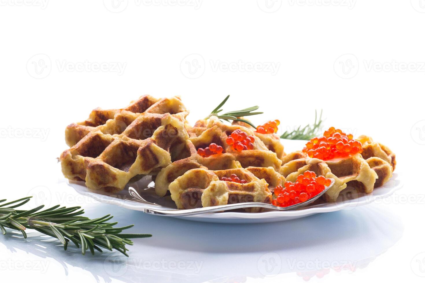 Delicious potato waffles with red caviar on a white background . photo