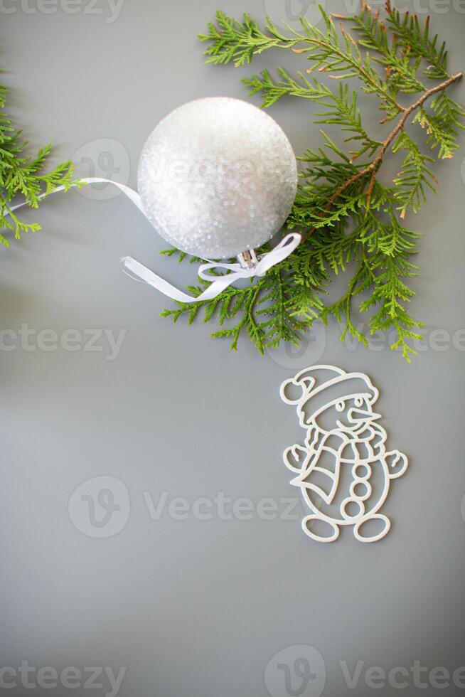 New Year's white ball and snowman on a background with a fir branch. photo