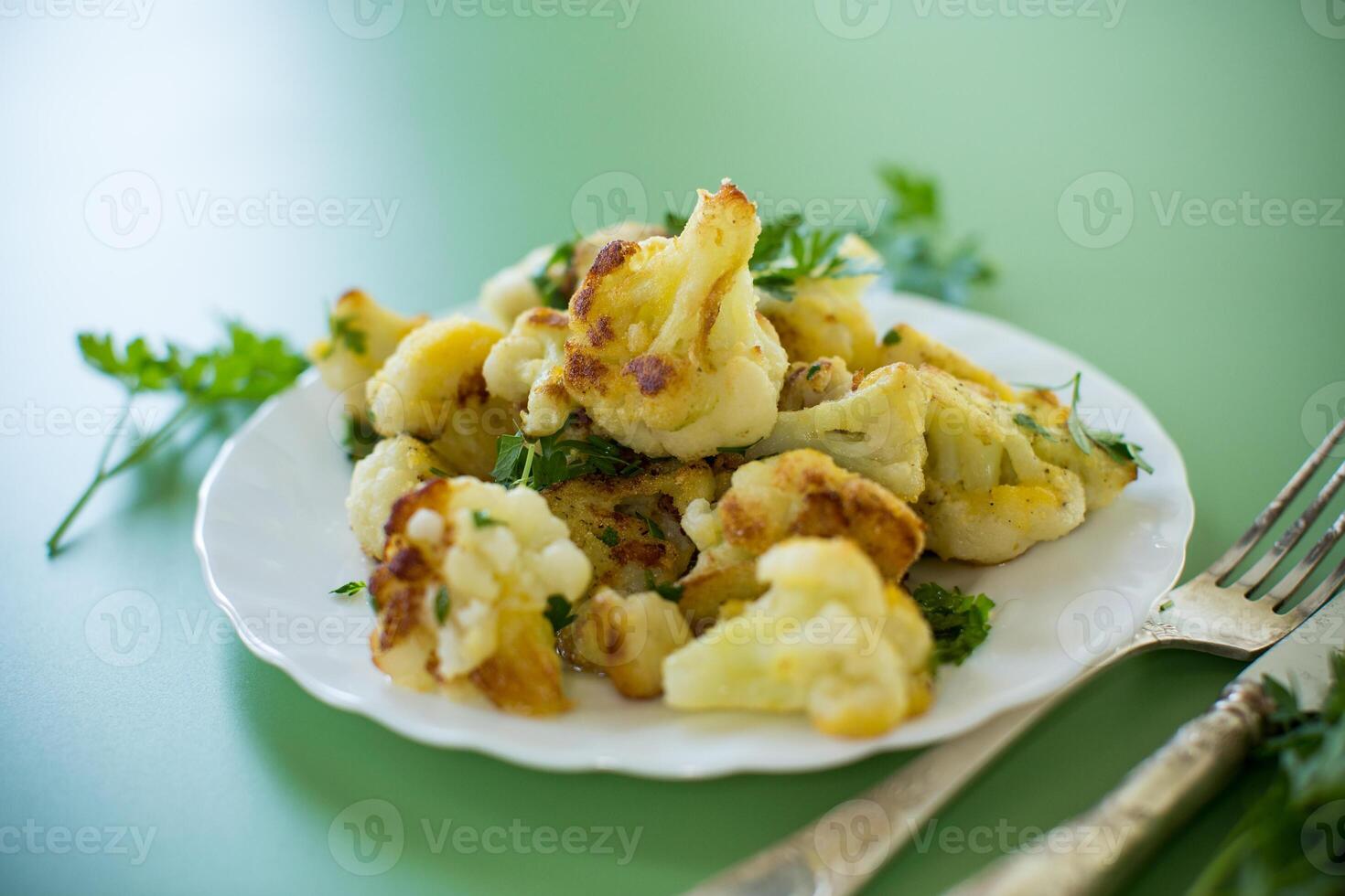 Vegetable dish of fried cabbage with aromatic spices on a green background photo