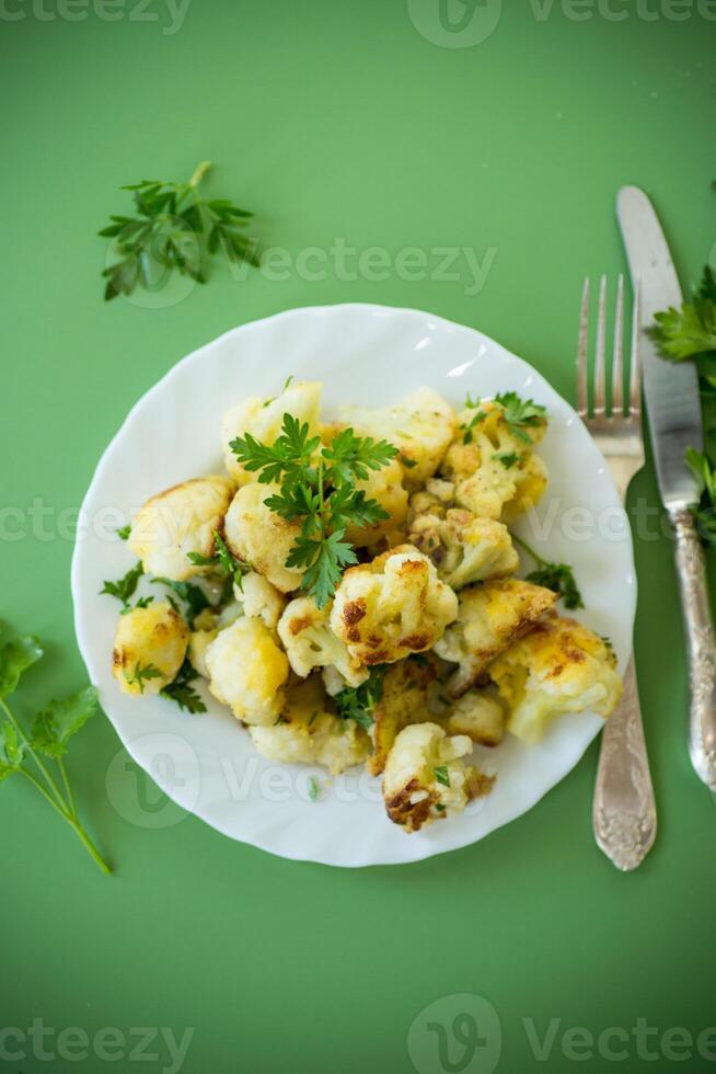 Appetizing fried cauliflower on a green background photo