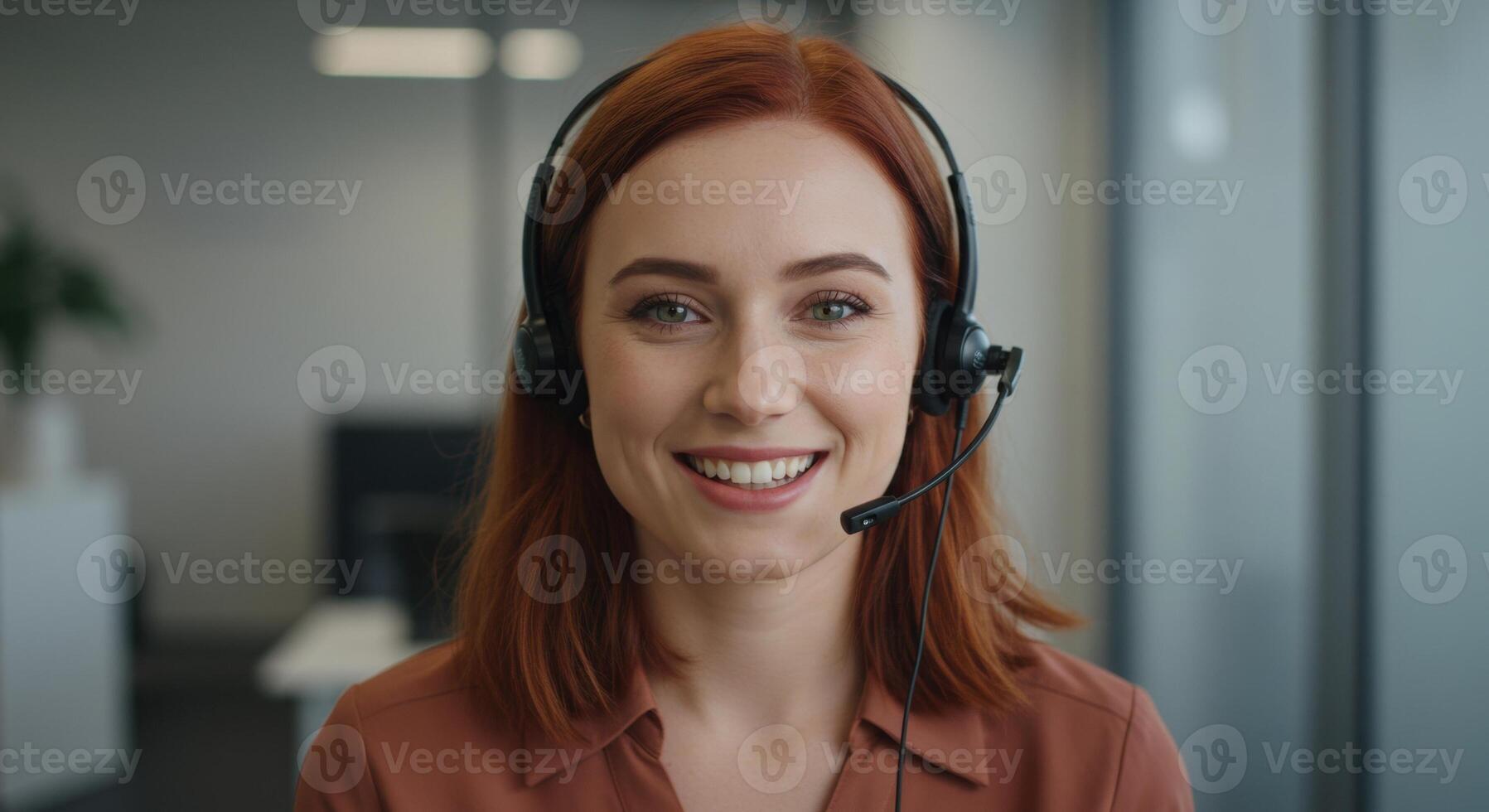 Friendly red haired woman wearing a headset, smiling while providing customer support in an office. photo