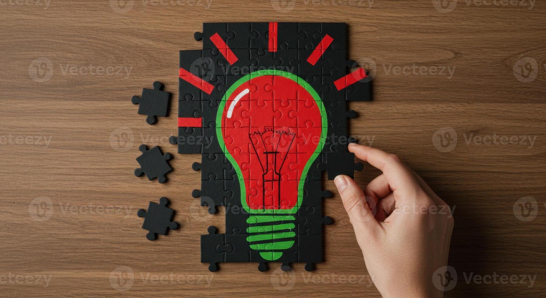 Hand completing a jigsaw puzzle forming a bright red light bulb, symbolizing a new idea or solution. photo