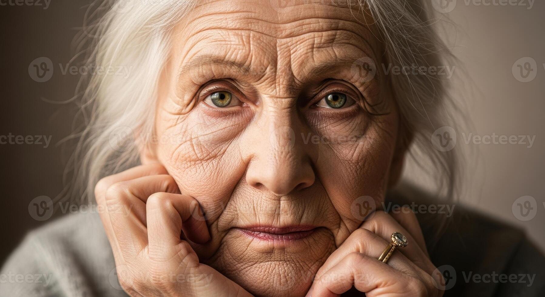 Close up portrait of an elderly woman with white hair, green eyes, and visible wrinkles photo