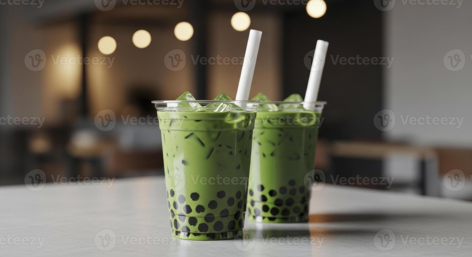 Two vibrant matcha bubble tea drinks with tapioca pearls and ice in clear cups on a cafe table. photo