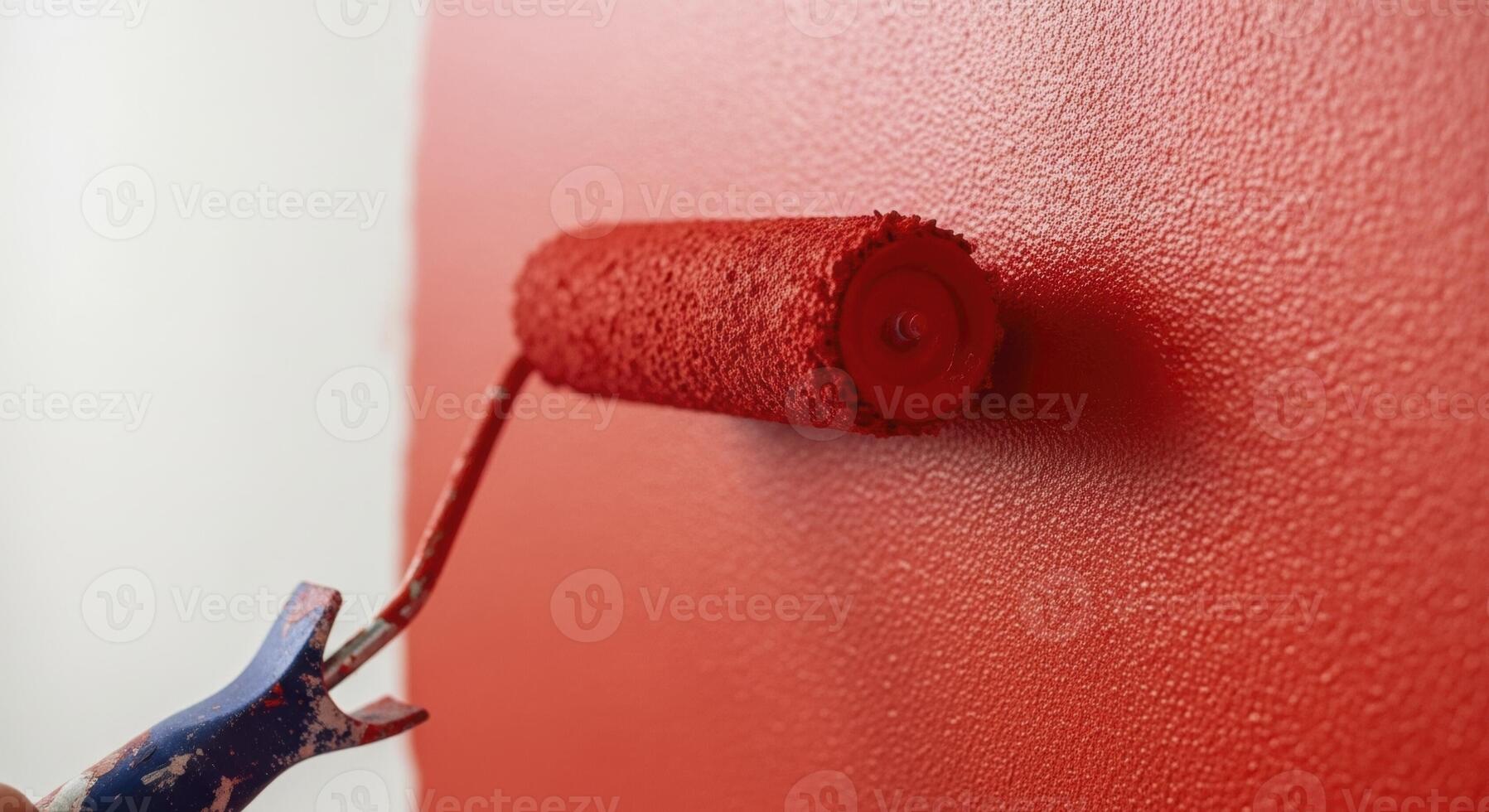 Vibrant red paint being applied to a textured wall with a paint roller during renovation. photo