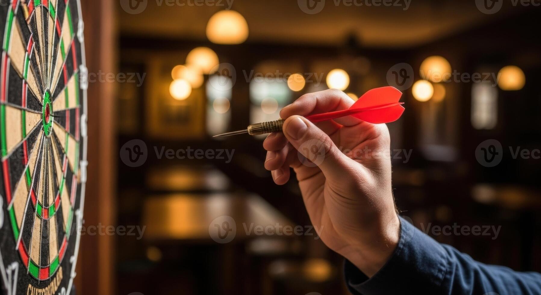 Close up of a hand holding a red dart aiming at a dartboard, ready to throw in a pub setting photo