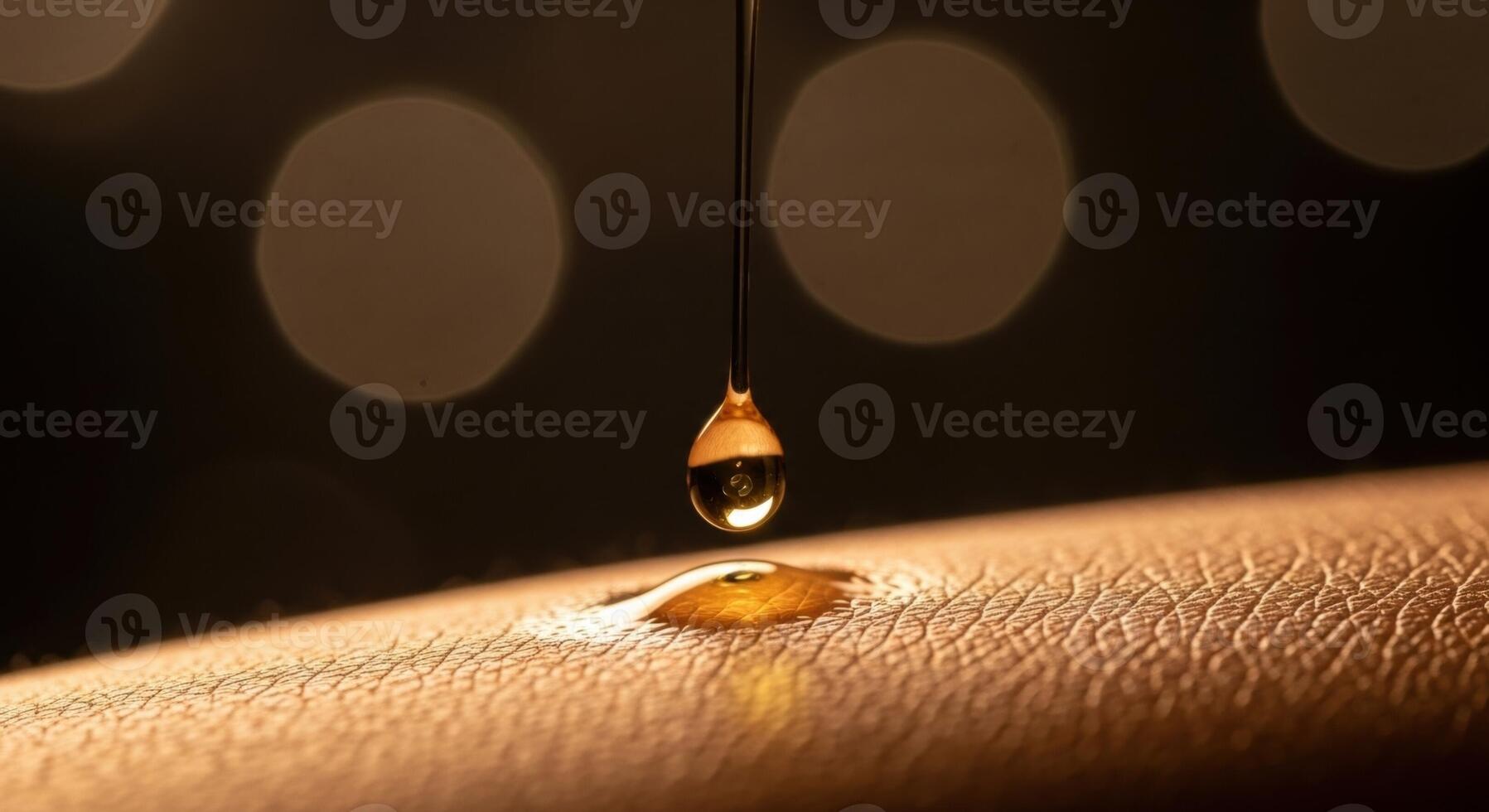 Golden liquid drop falling onto smooth skin for beauty and hydration concept photo
