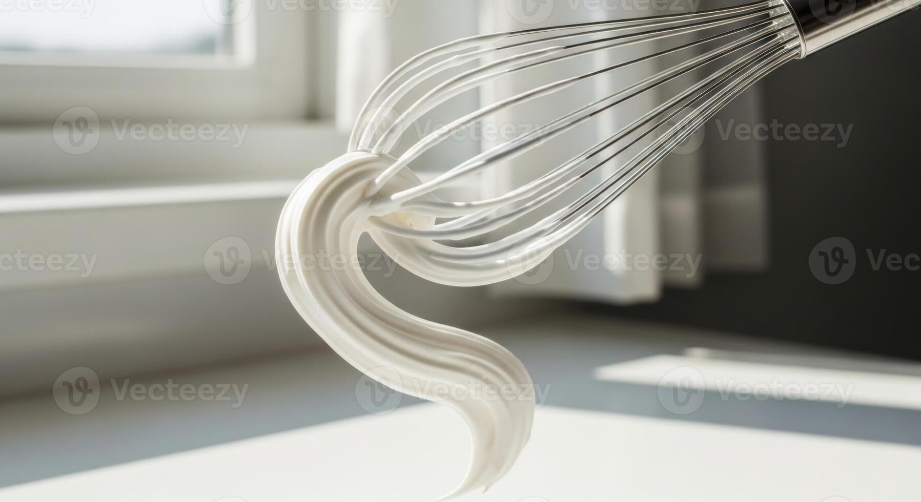 Metal whisk with white whipped cream in motion, highlighting baking and culinary preparation photo