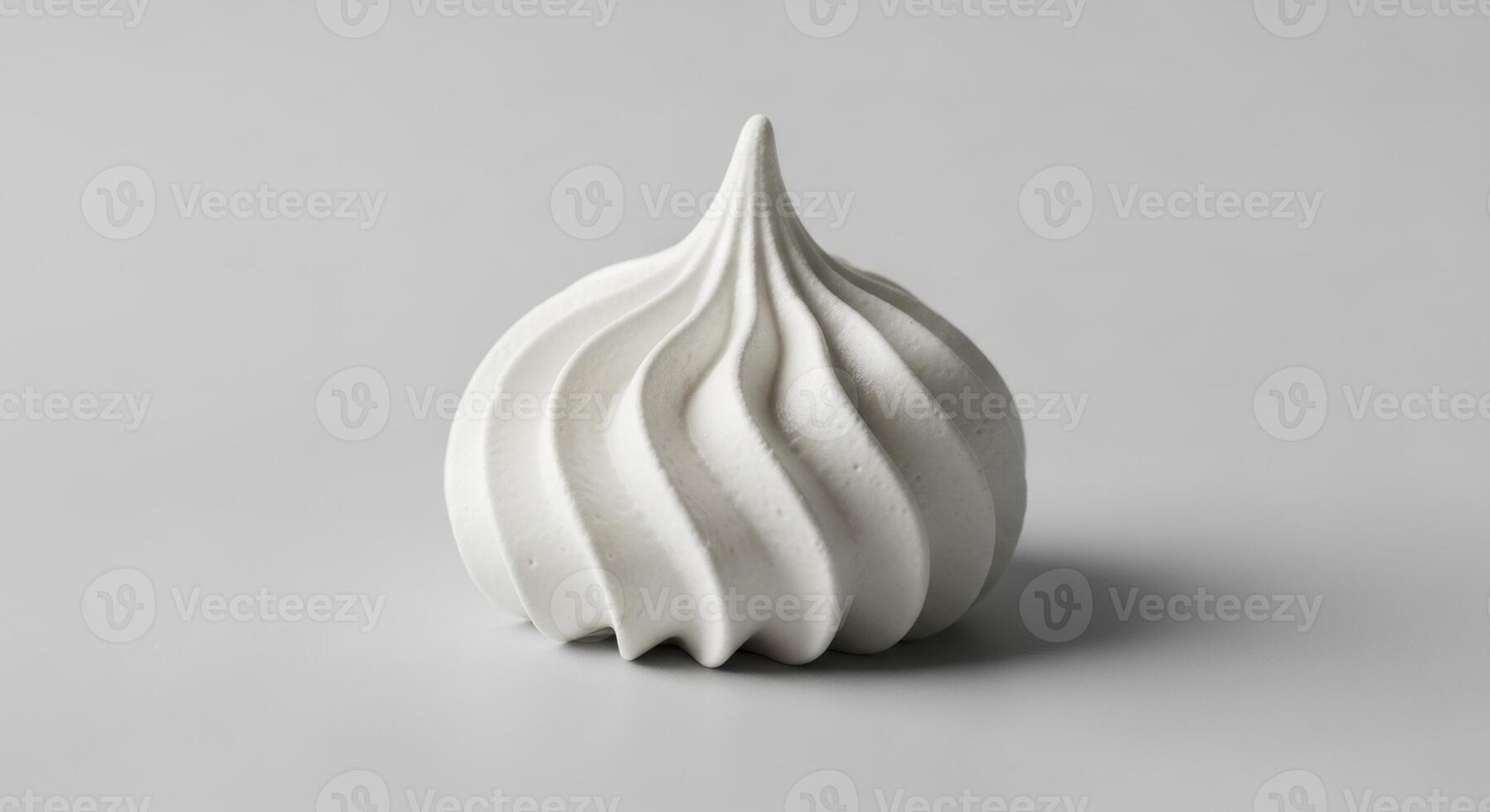 High quality studio photograph of a single white meringue cookie with a distinct swirl pattern photo