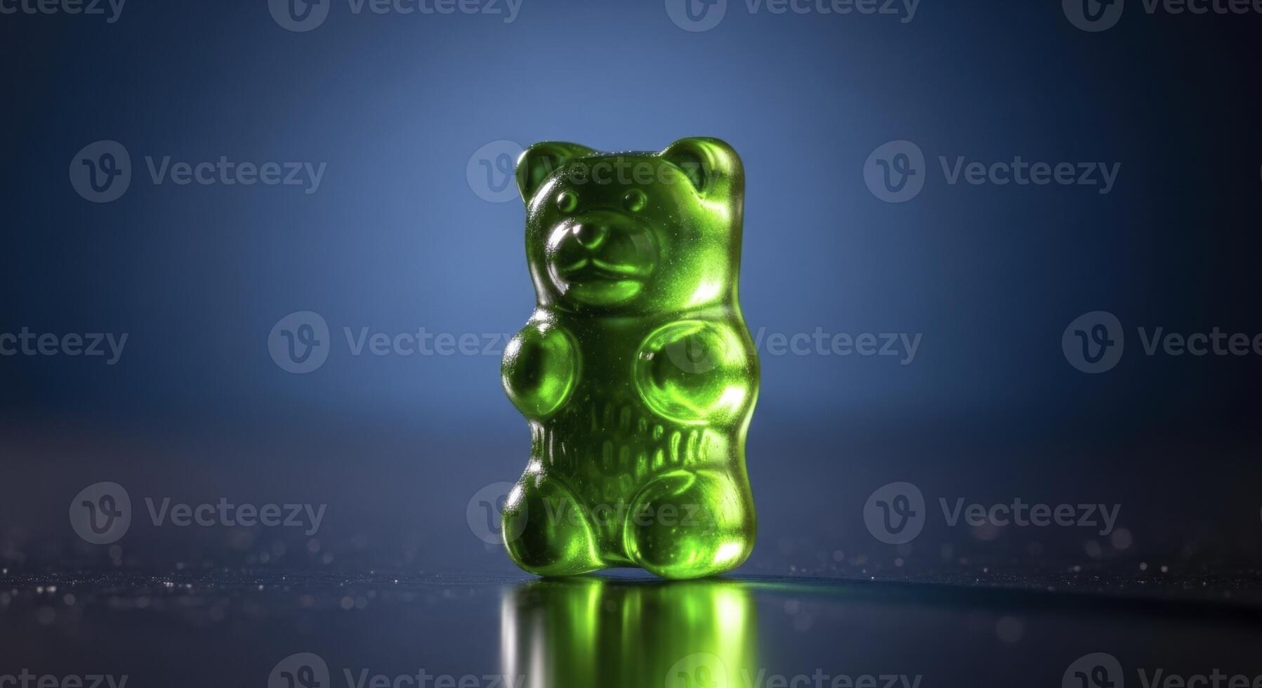 Bright Green Gummy Bear Standing on Reflective Surface with Dark Blue Background photo