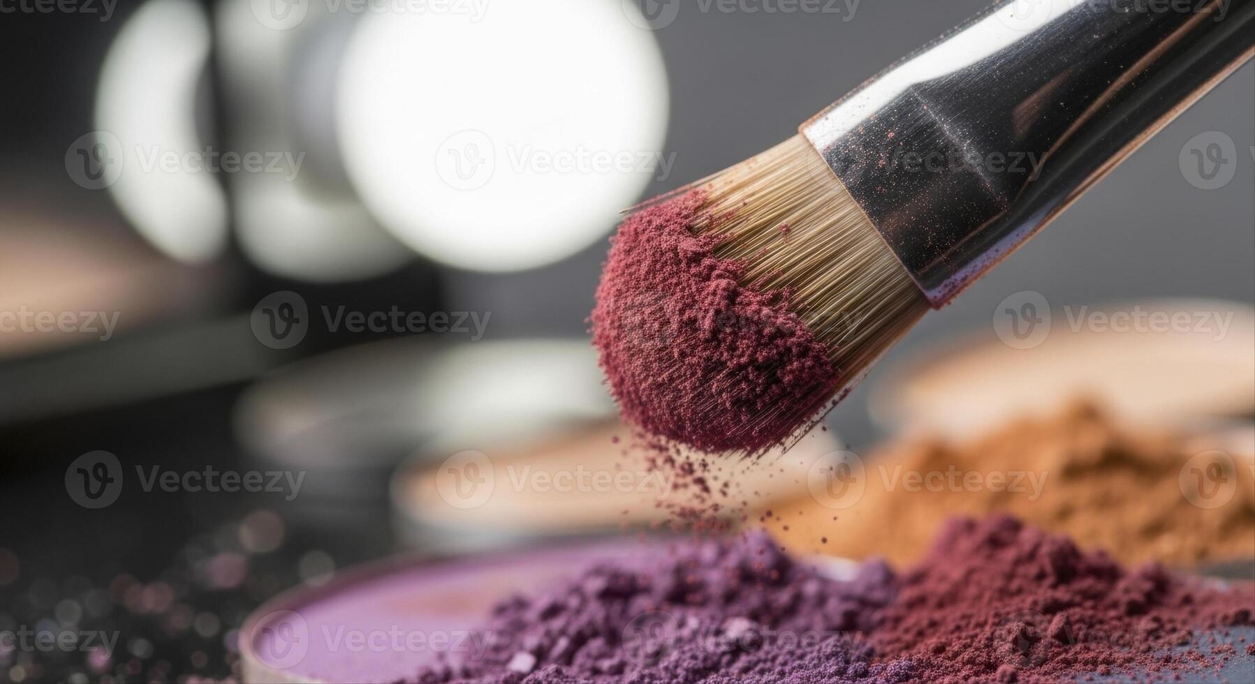 Close up of a makeup brush with burgundy eyeshadow powder and scattered pigments photo