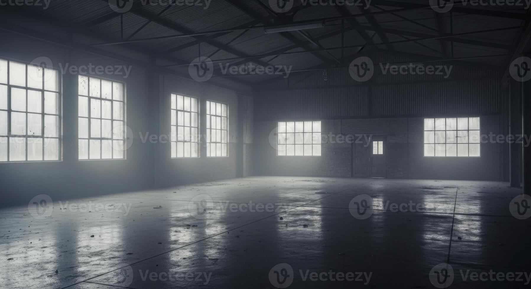Empty dark industrial warehouse interior with large windows and dusty concrete floor photo