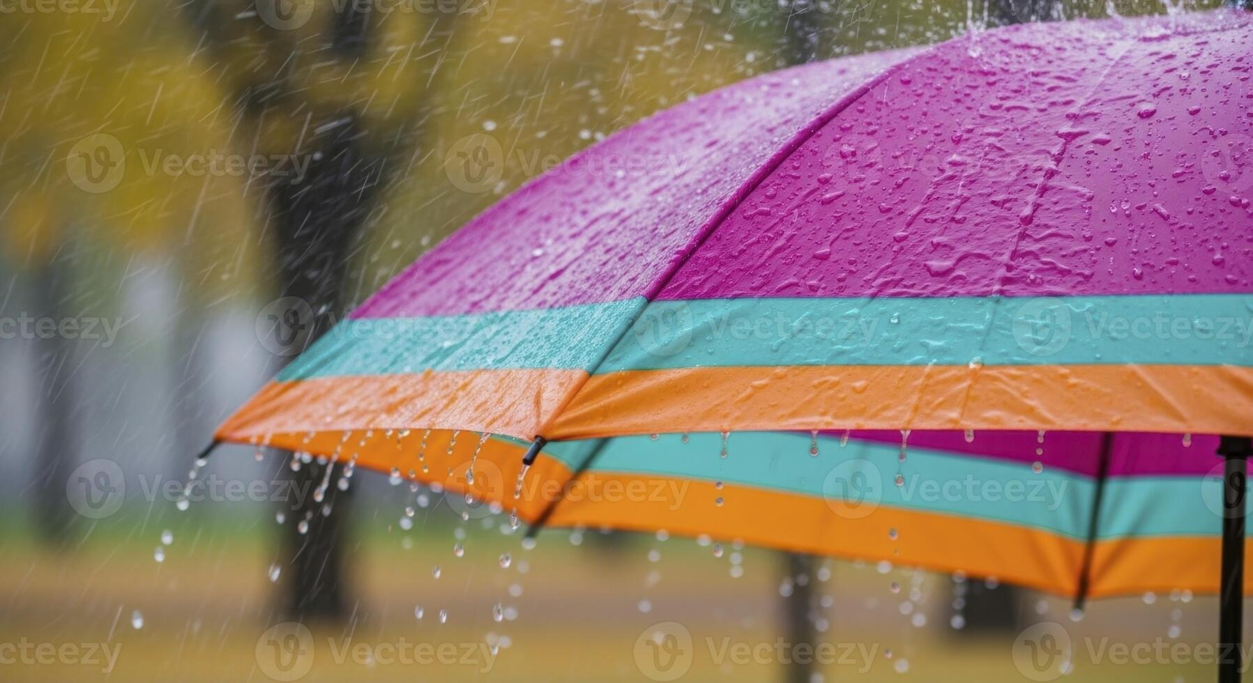 Vibrant Striped Umbrella Covered in Raindrops During a Heavy Autumn Downpour photo