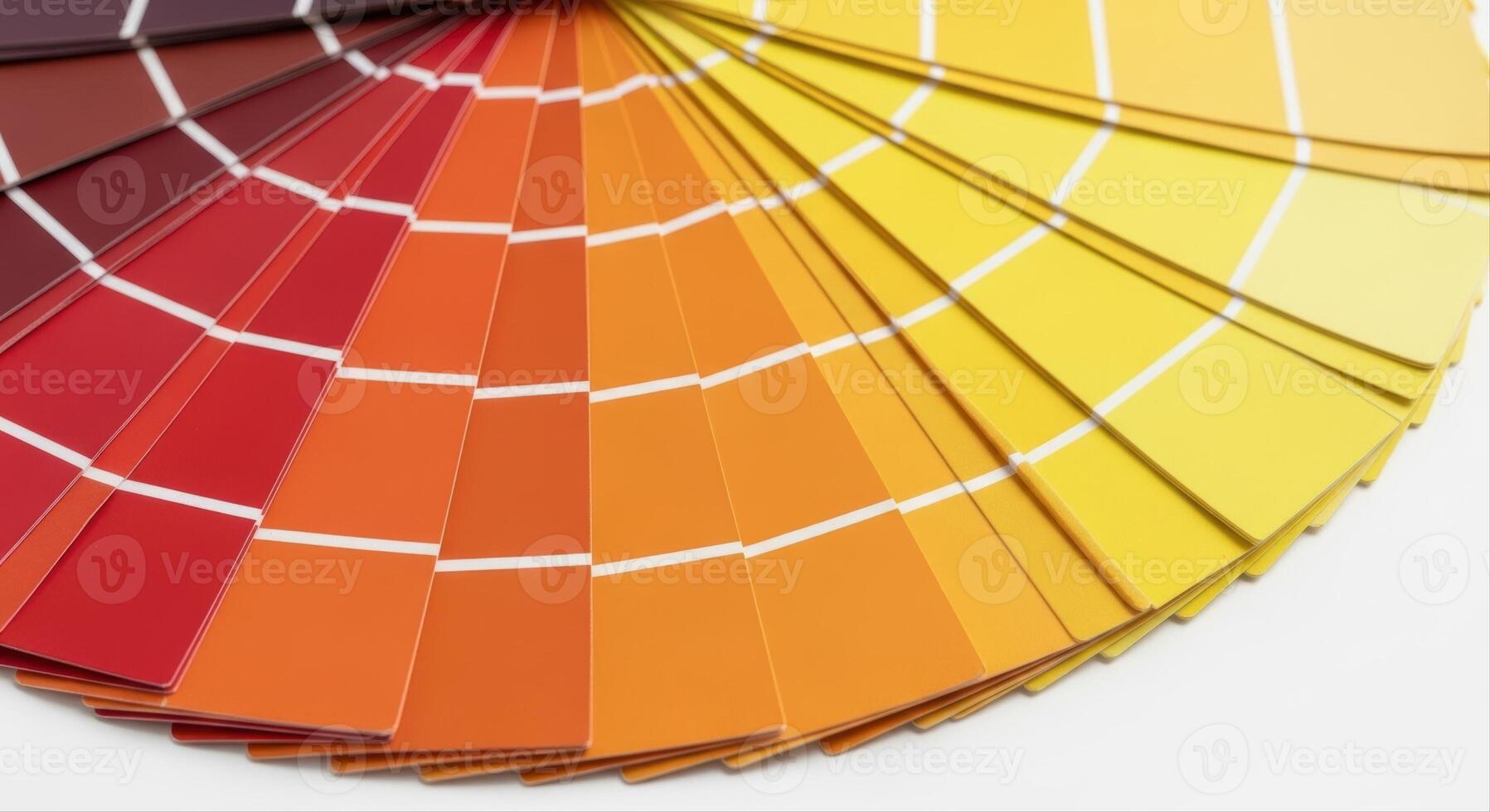 Fanned out color swatch book displaying warm tones of red, orange, and yellow for design inspiration photo
