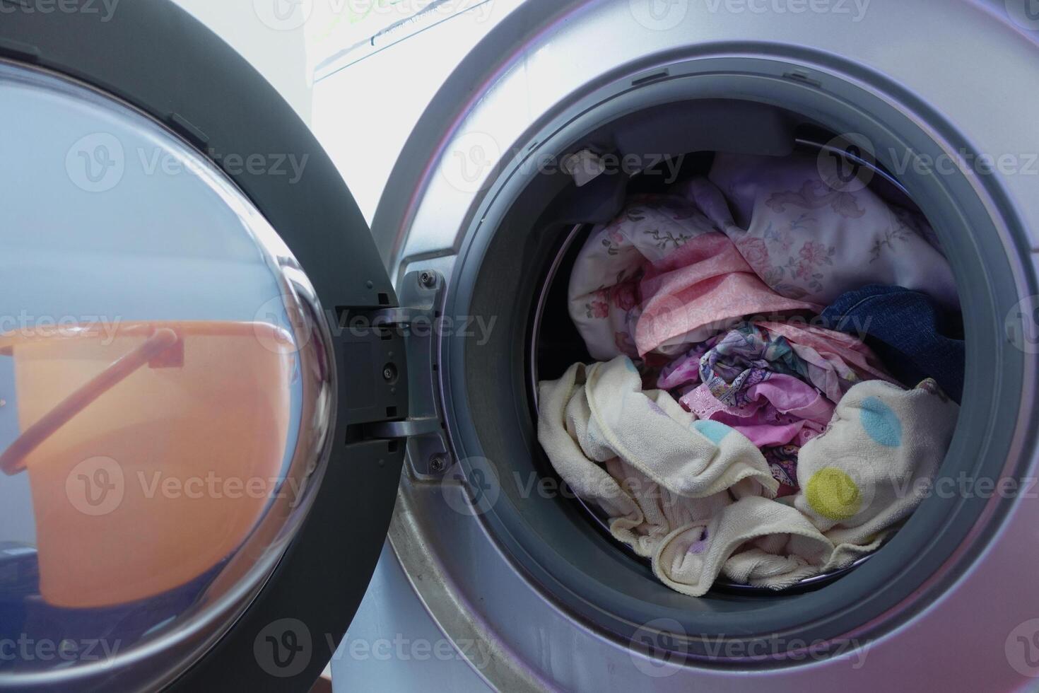 Washing machine loaded with clothes ready for a cycle photo
