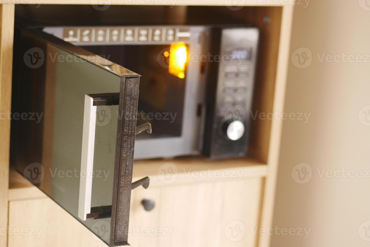 Microwave with open door and warm light glowing inside photo