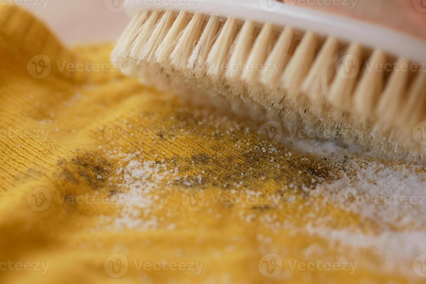 Cleaning a yellow fabric with a brush and baking soda photo