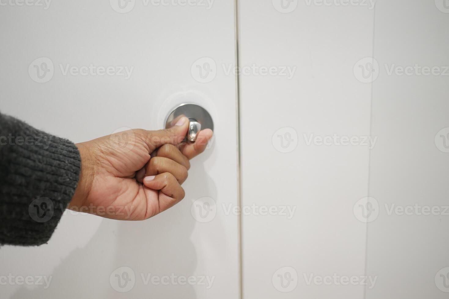 Hand reaching for a door handle in a modern setting photo