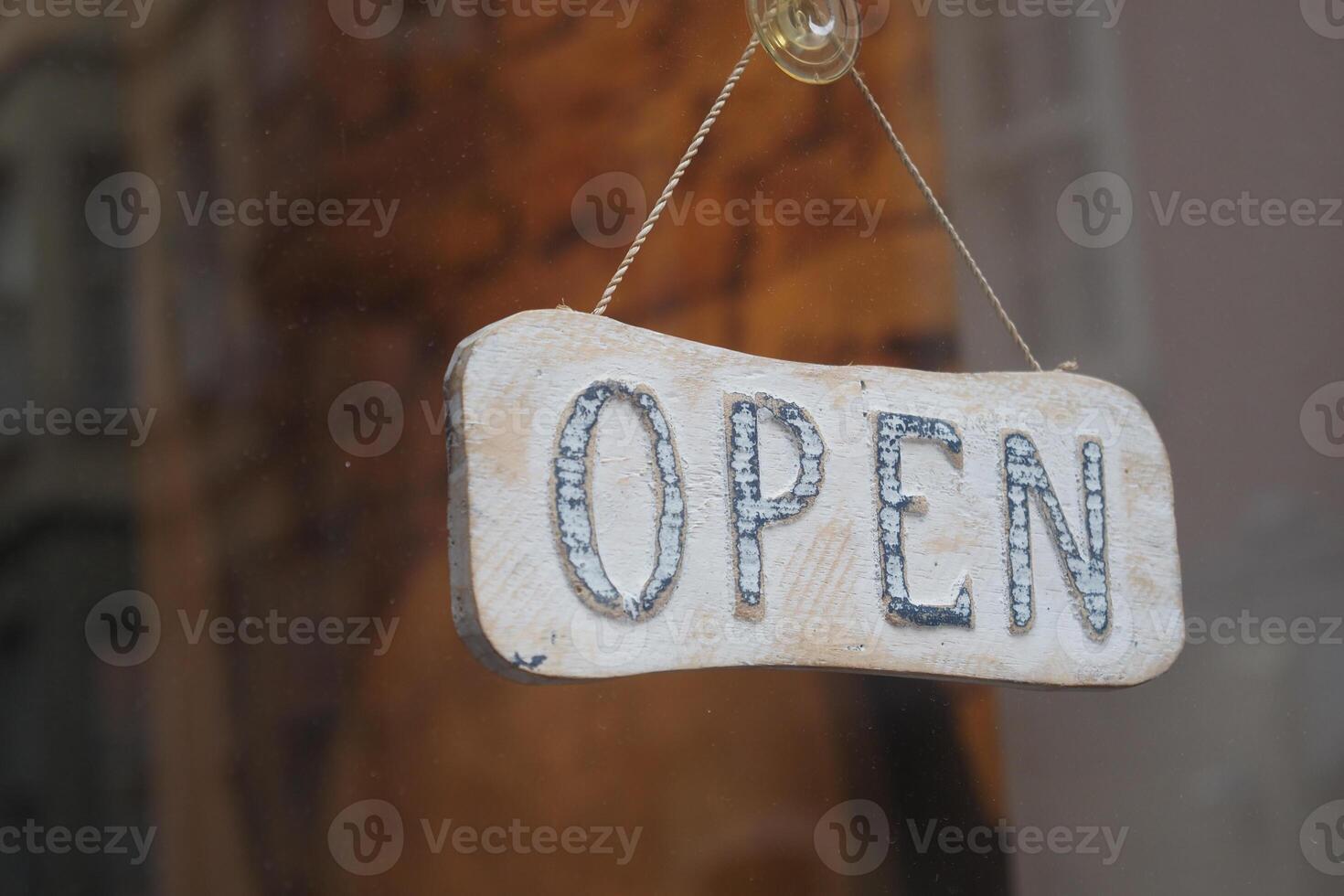 Wooden open sign displayed in storefront window photo