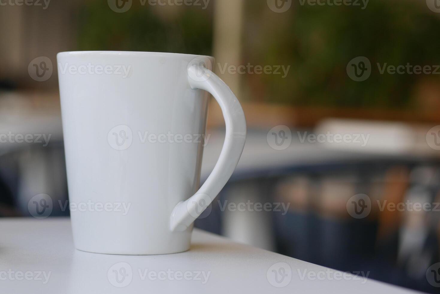 White mug on table in a cozy cafe setting photo