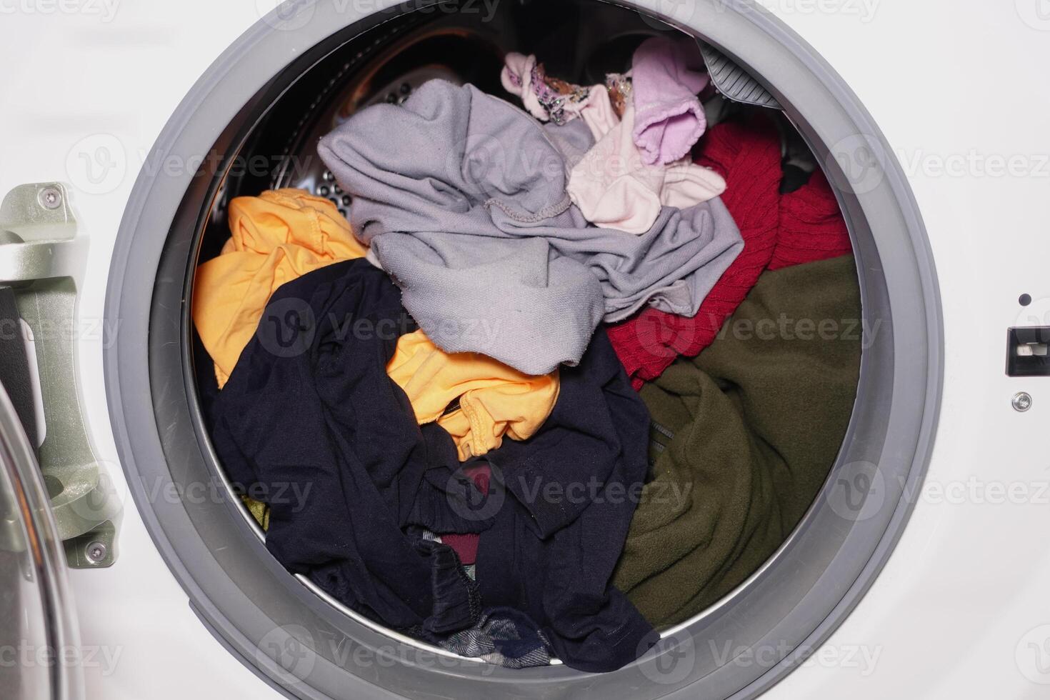 Clothes being washed in a laundry machine drum photo