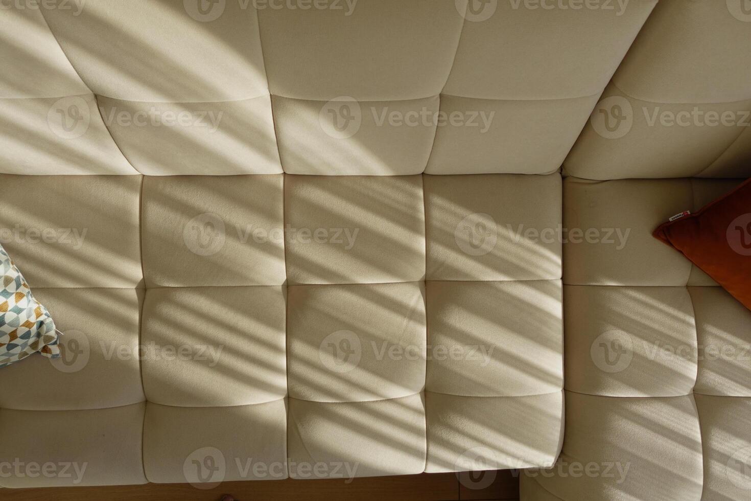 Sunlight casting shadows on a cozy couch in morning hours photo