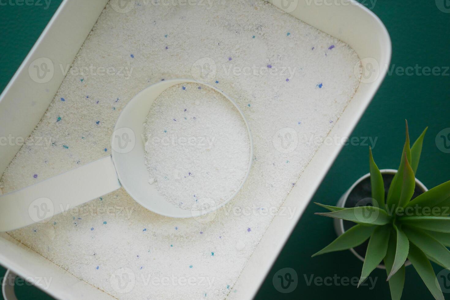 Laundry detergent in a container with a measuring scoop photo