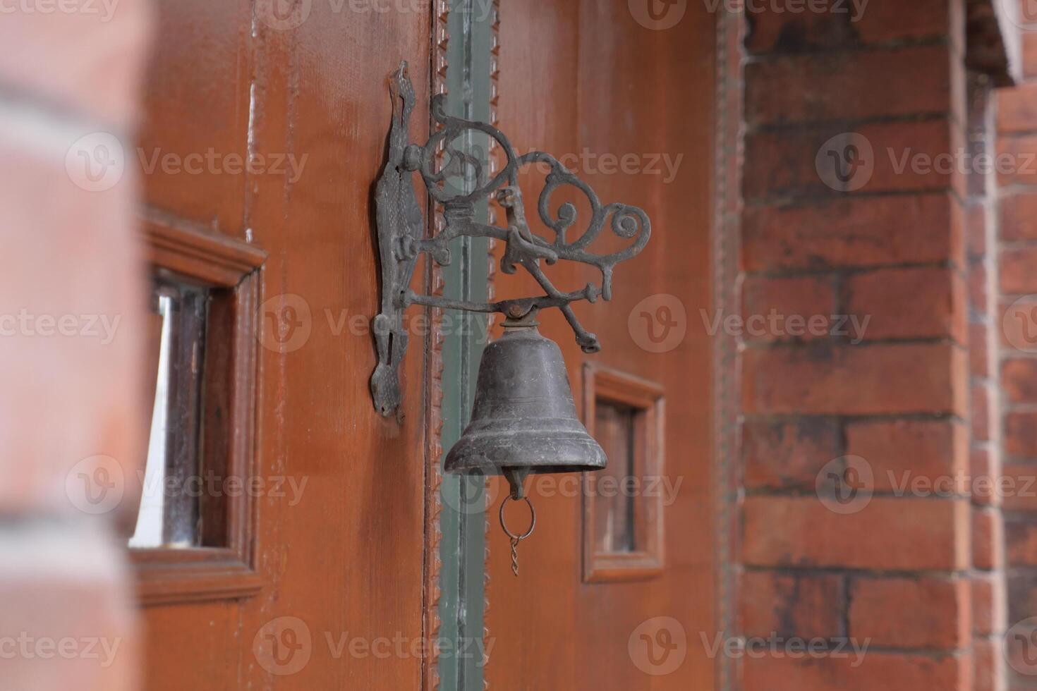 Vintage bell mounted on rustic wooden door photo