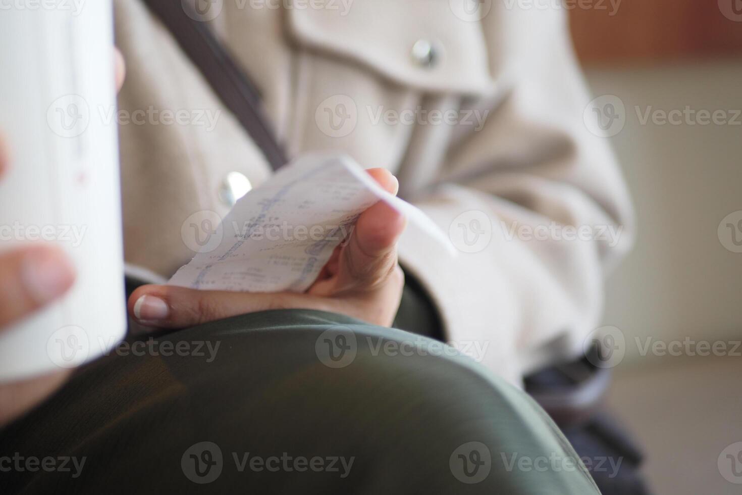 Holding a receipt while drinking coffee at a quiet cafe photo