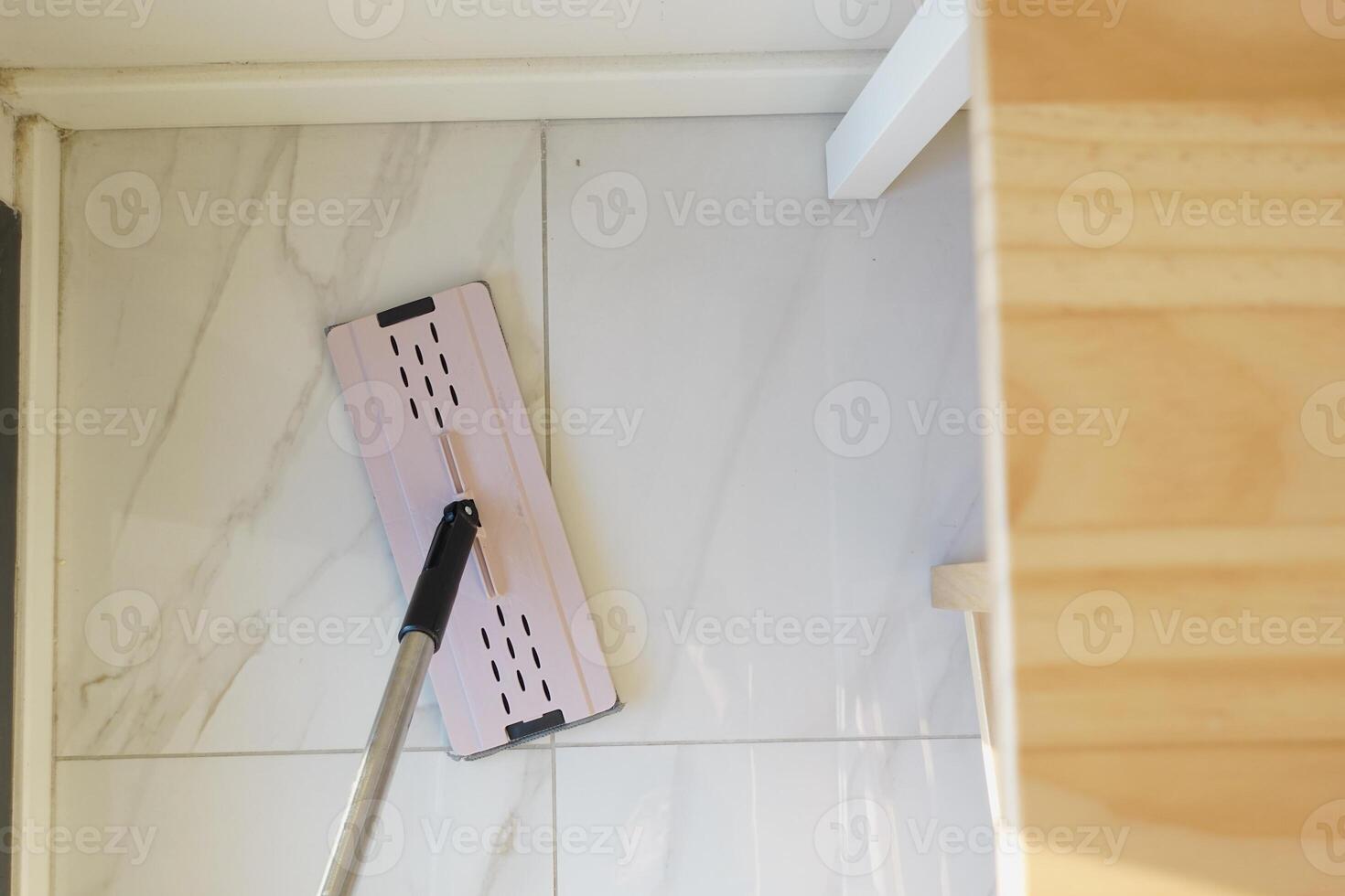 Cleaning the floor with a mop during home maintenance photo