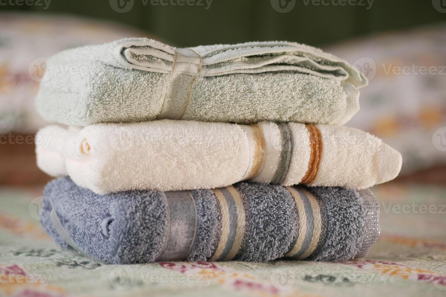 Towels neatly organized on a colorful bed spread photo