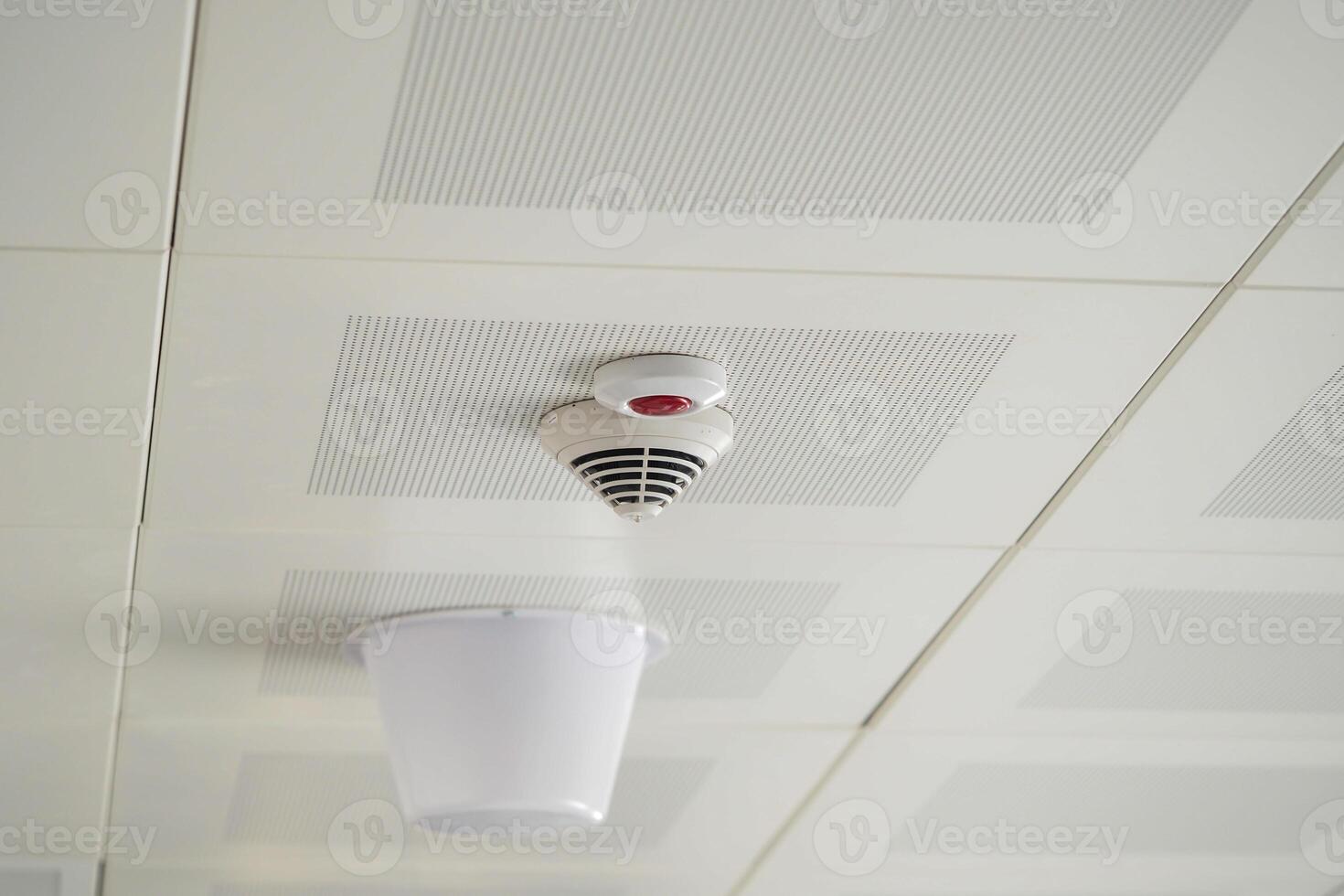 Smoke detector installed on ceiling in a modern building photo