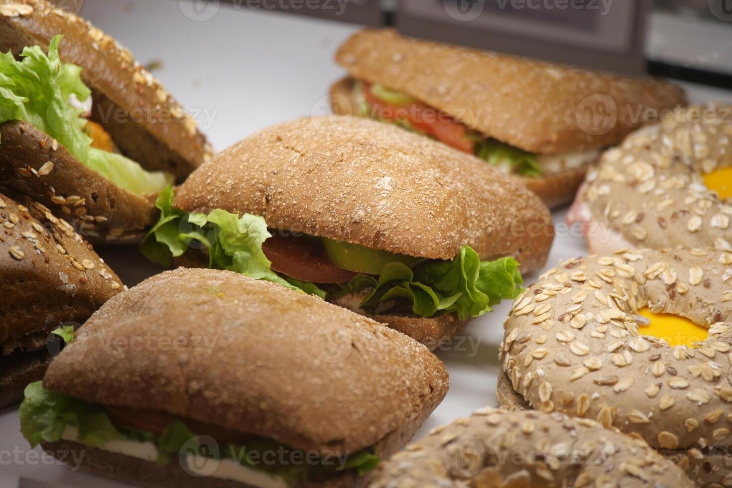 Fresh sandwiches and rolls displayed in a bakery showcase photo