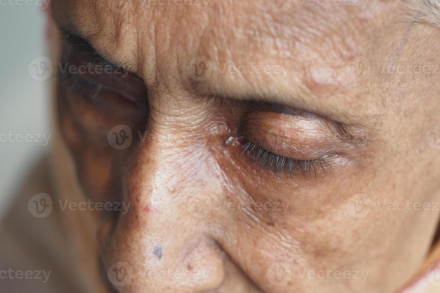 Elderly woman with closed eyes showing deep emotion photo