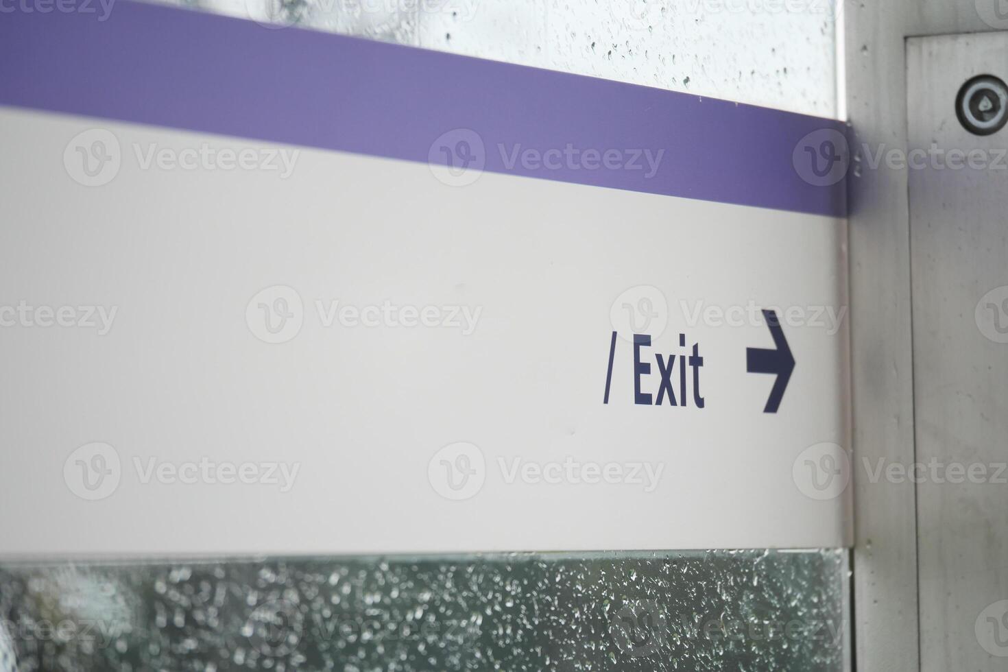 Clear exit sign with directional arrow in rainy setting photo