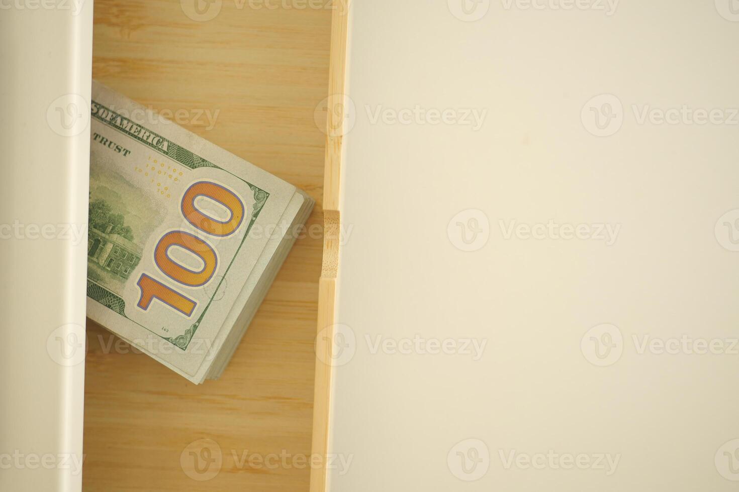 Money placed in a wooden drawer for safekeeping photo