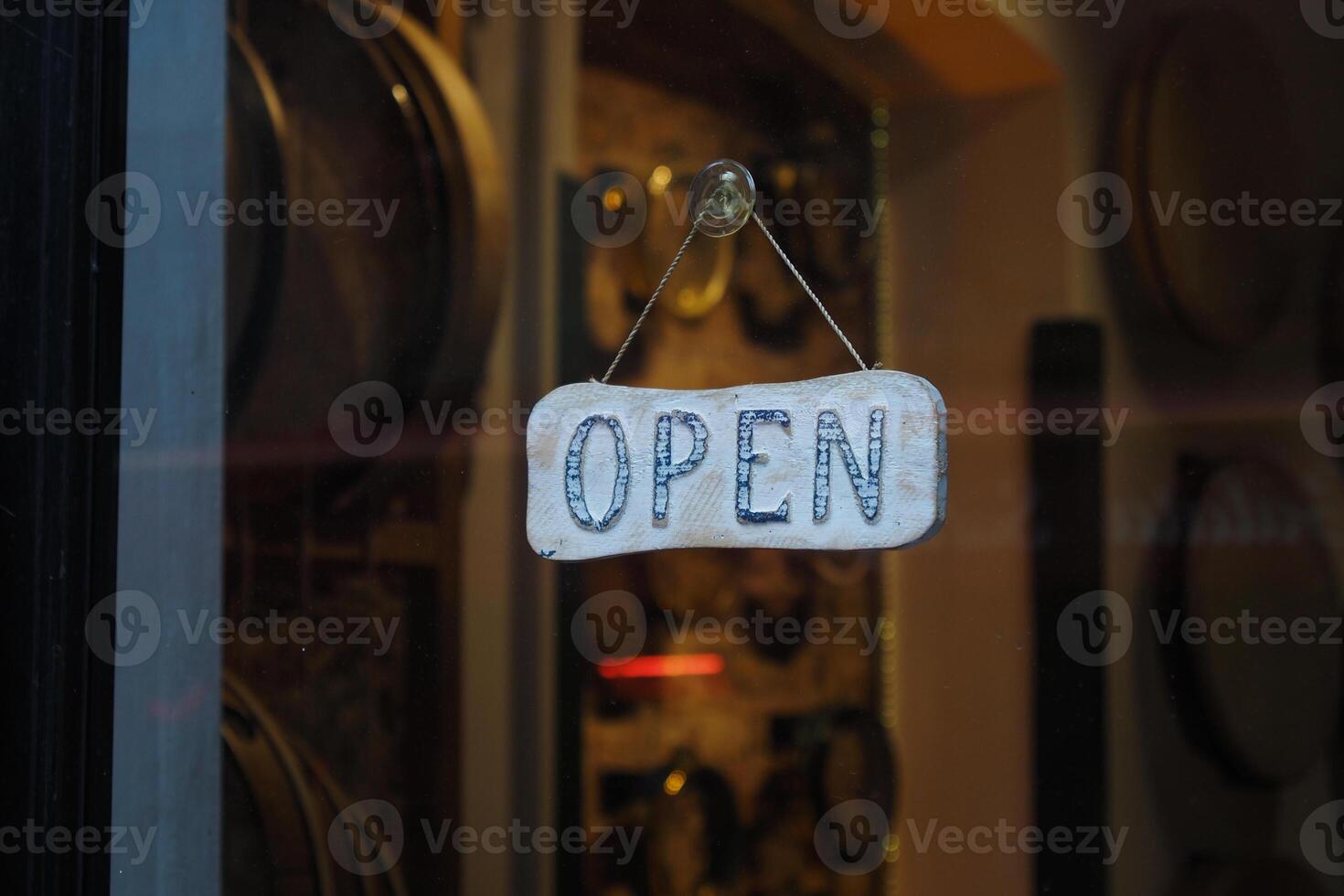 Open sign hangs in the window of a small shop photo
