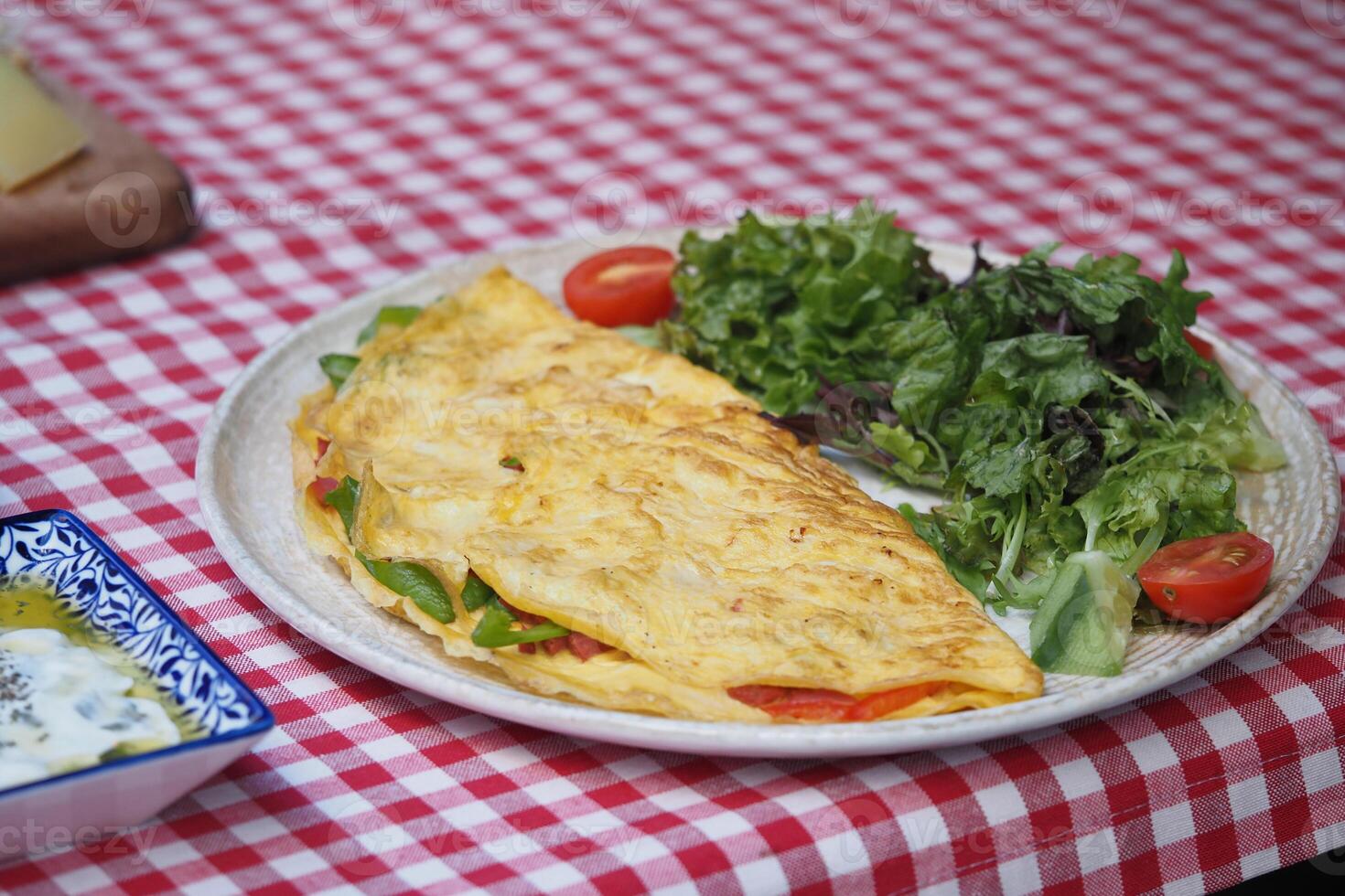 Vegetable omelette with salad on checkered table photo