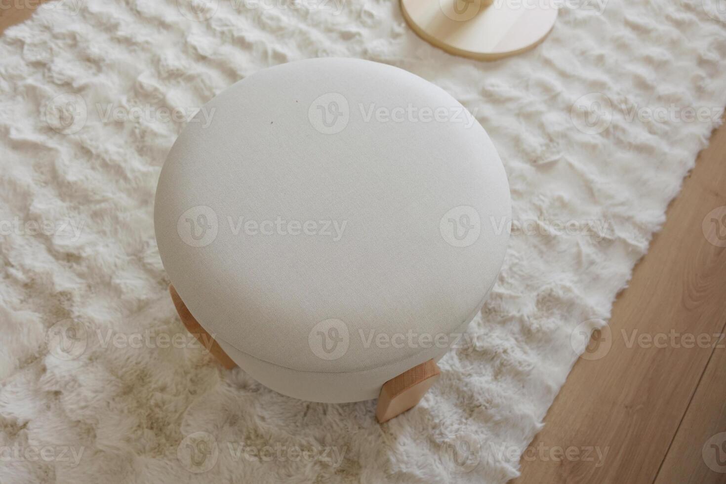White round stool on textured rug in cozy interior design photo