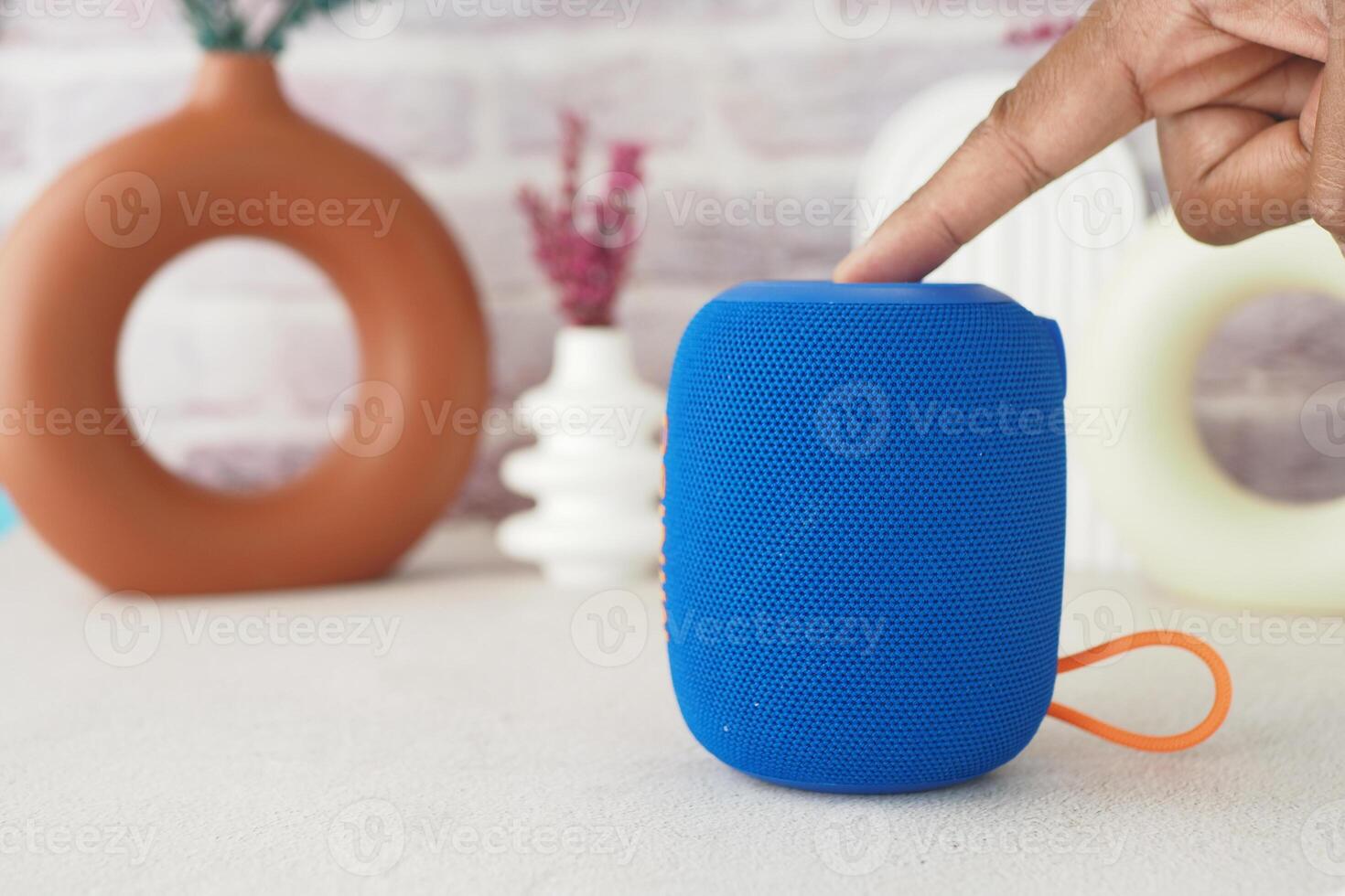 Bright blue portable speaker on a light surface with decor photo