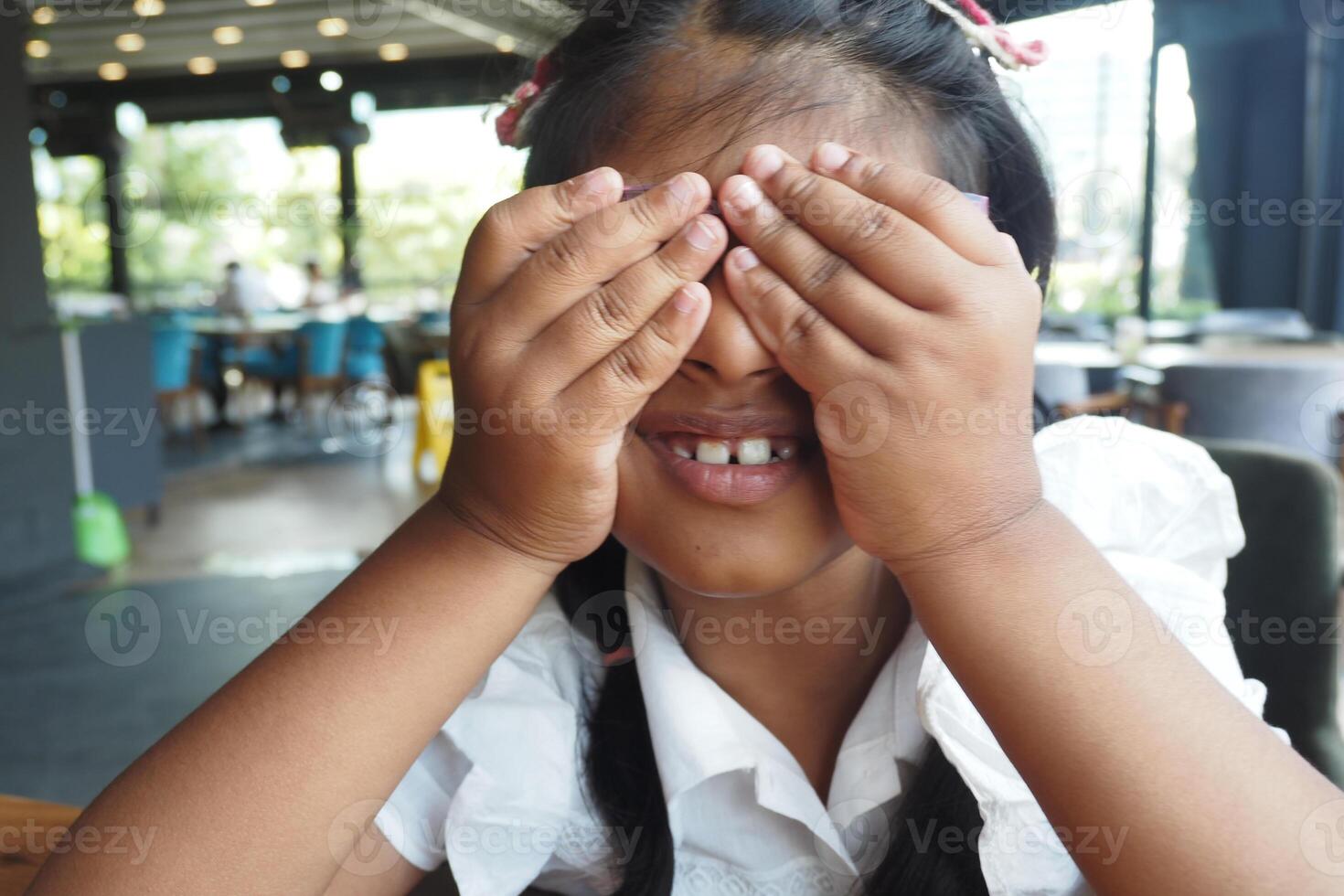 Girl playfully hiding her eyes during a fun moment photo
