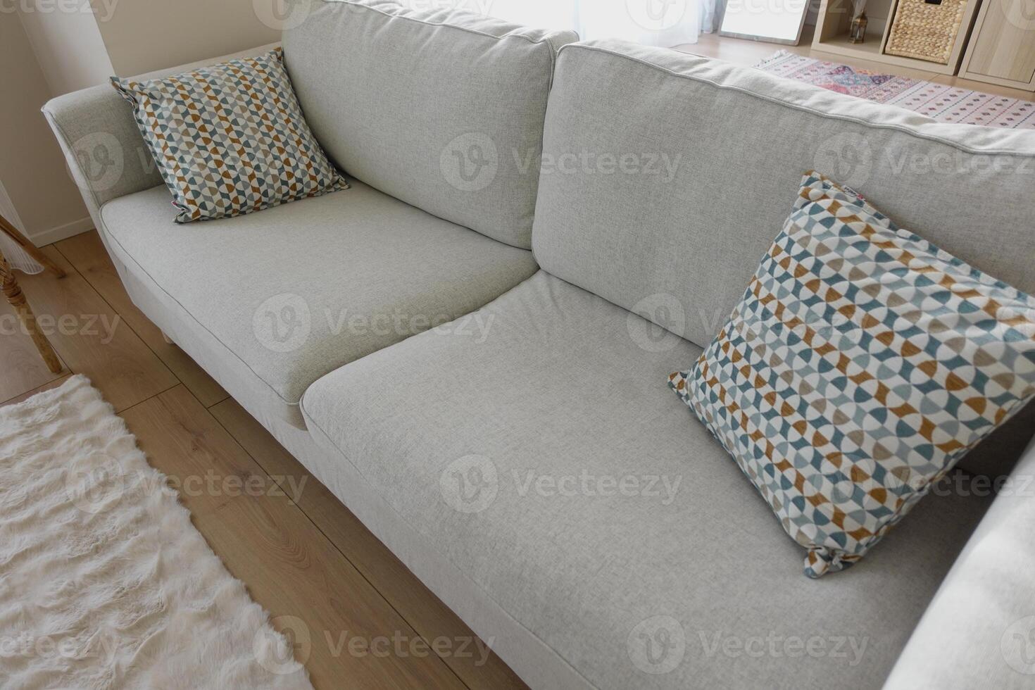 Cozy living room sofa with patterned cushions in daylight photo