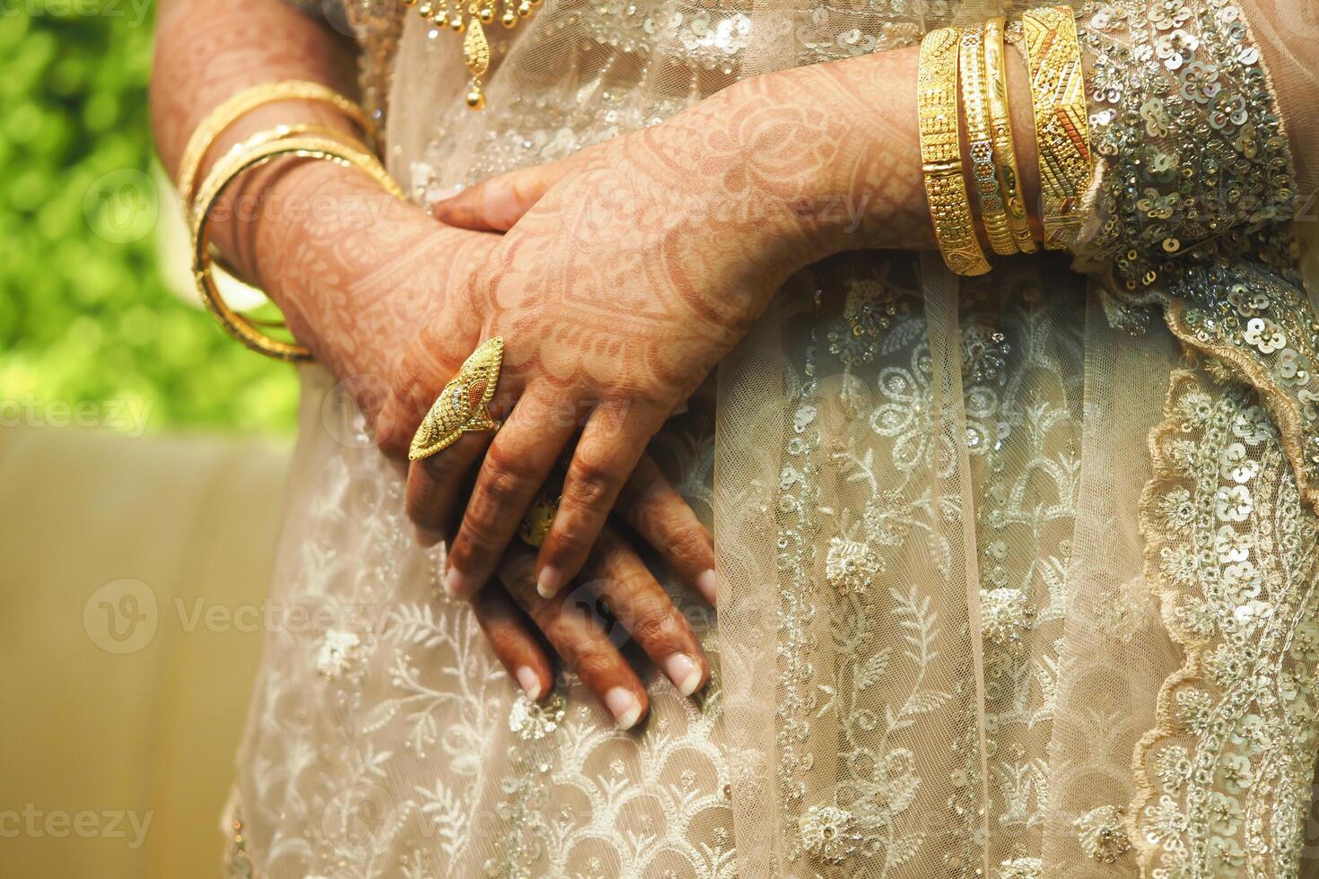 Hands decorated with henna and gold jewelry showcase cultural elegance photo