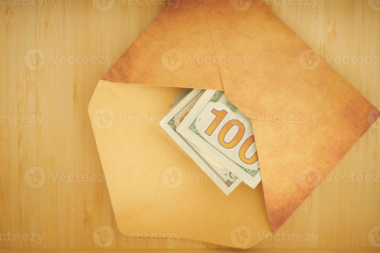 Money tucked in an envelope on a wooden background photo