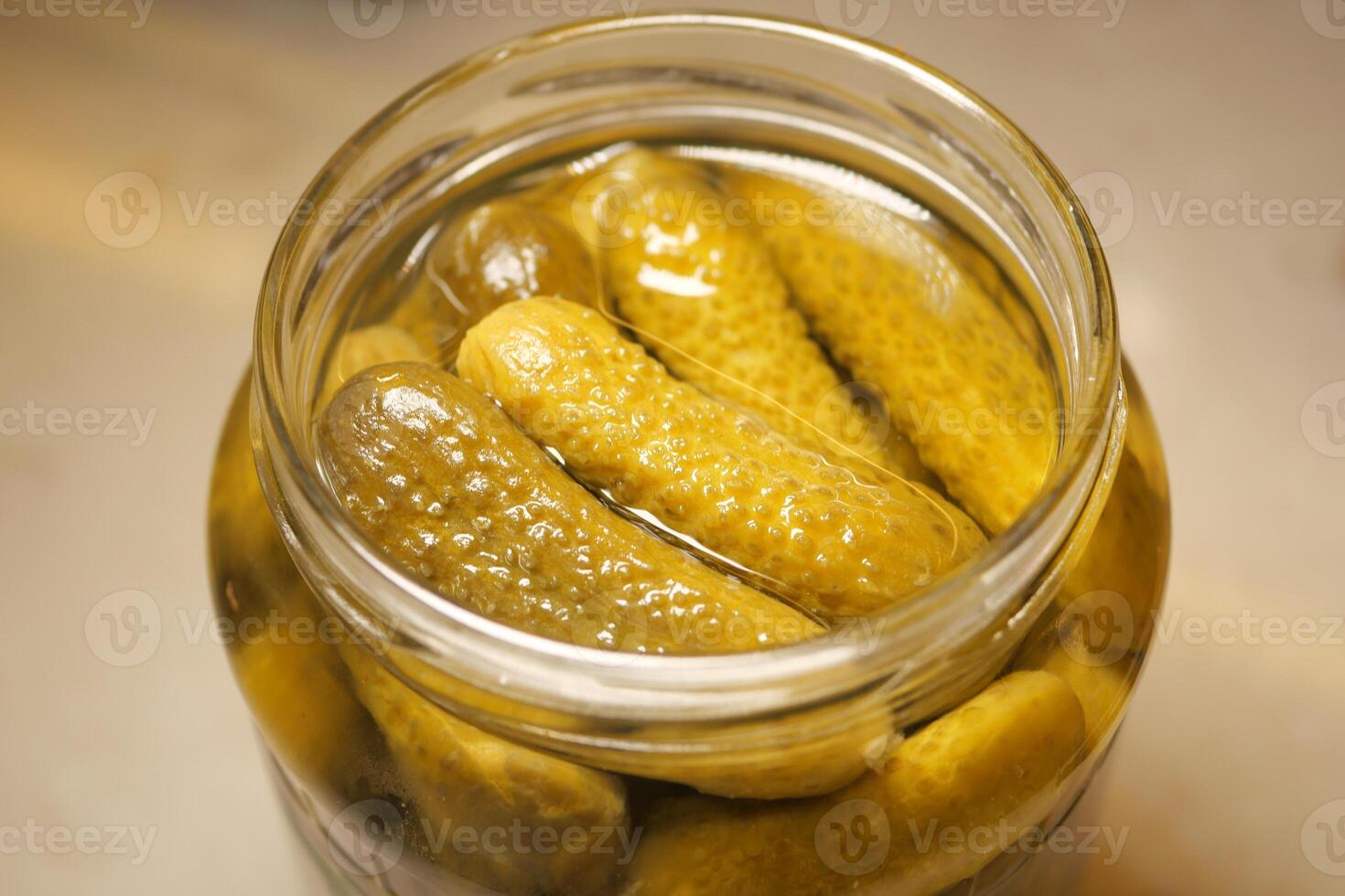 Cucumbers preserved in glass jar for fresh pickling photo