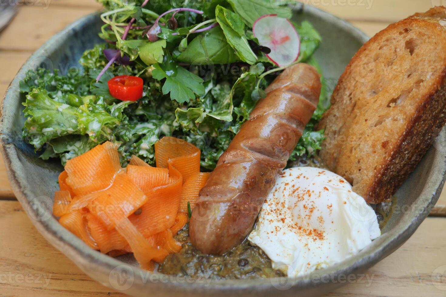 Delicious breakfast bowl with sausage, greens, and bread photo