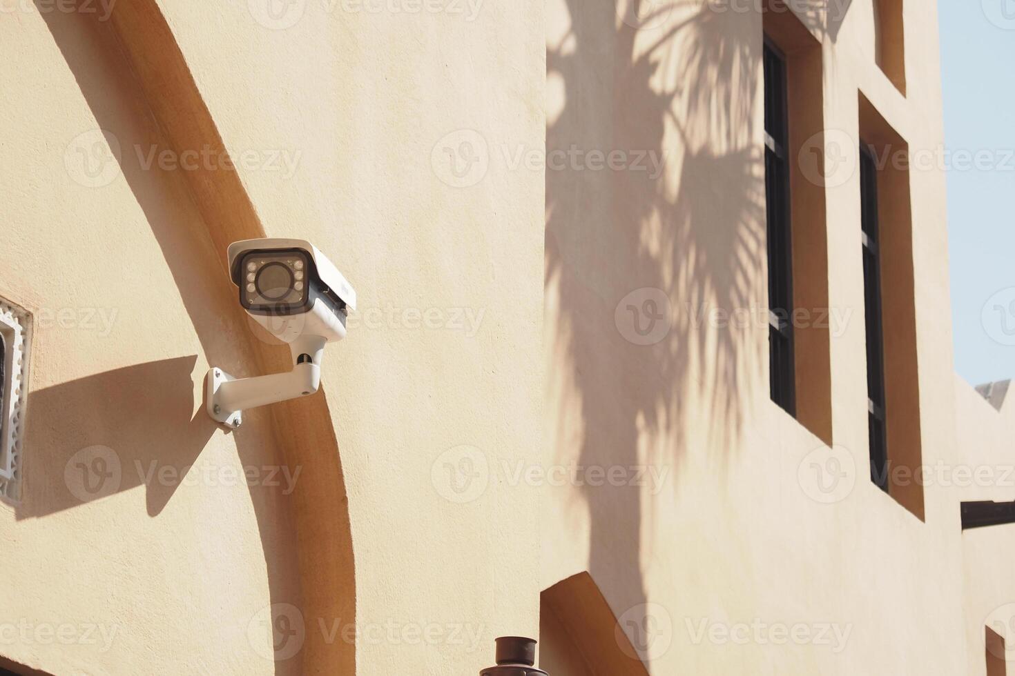 Security camera mounted on a stucco building exterior photo