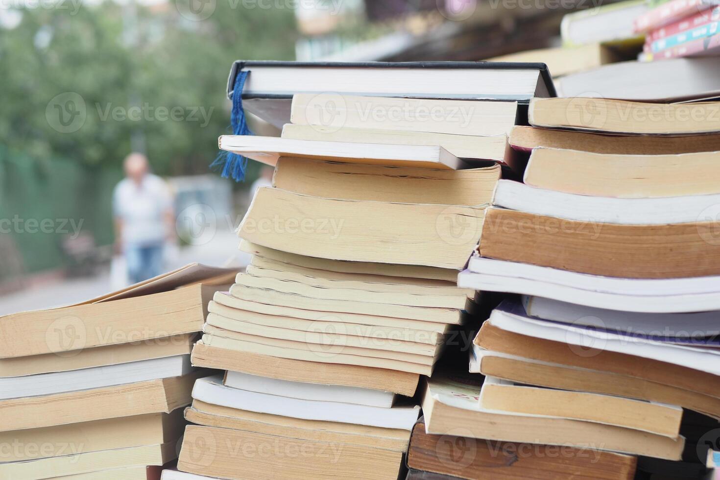 Books stacked outside a shop in a busy urban area photo