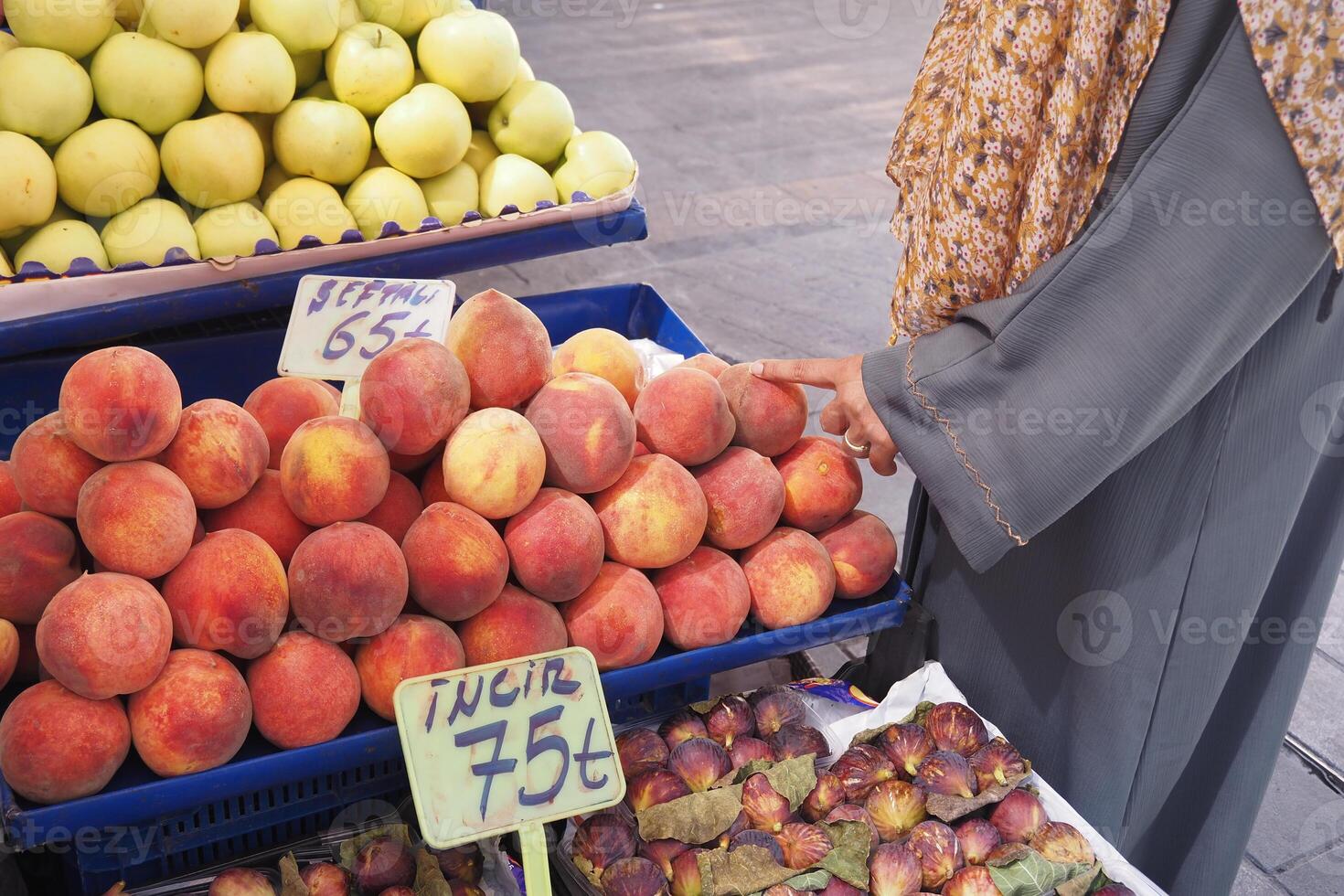Woman shopping for fresh peaches at a local market photo